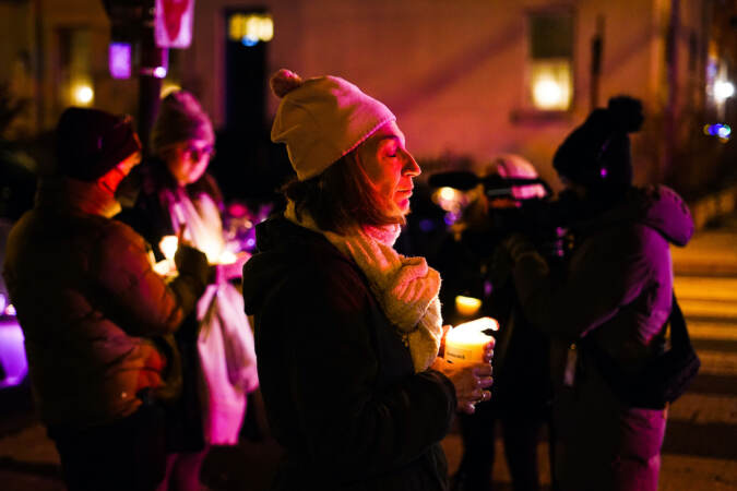 People gather to pay their respects after a deadly rowhouse fire