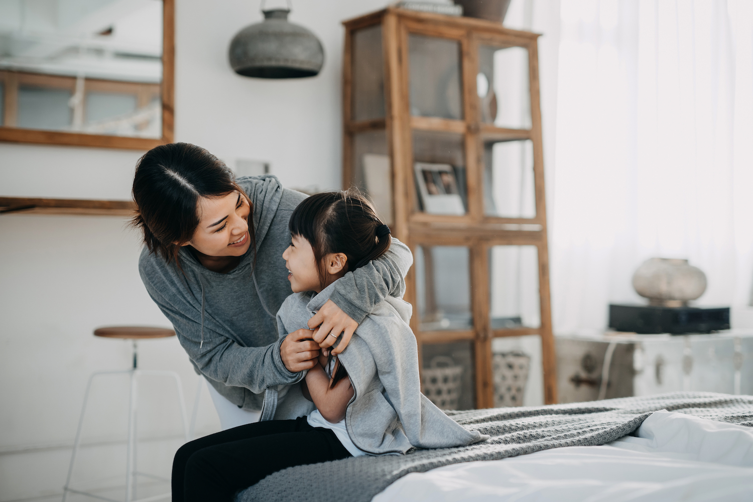 mother putting blanket around daughter