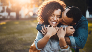 African american couple embracing effecionately outdoors in a park.