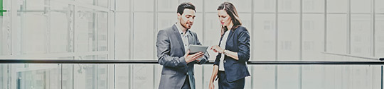 Two coworkers conversing on a sky bridge