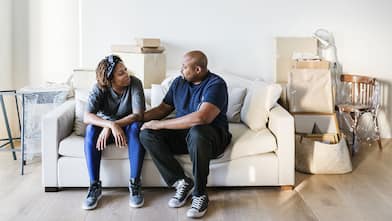 Couple sitting on couch, moving into new house