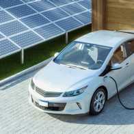 An electric car being charged in a driveway