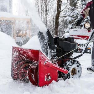 A man using a red snowblower