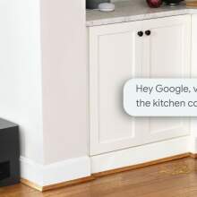 Roomba j7+ and dock on floor in a kitchen with Google Assistant text bubble