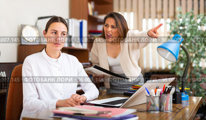 Unhappy woman chief screaming to young female manager