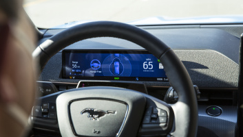 A driver looks at the screen behind the wheel.