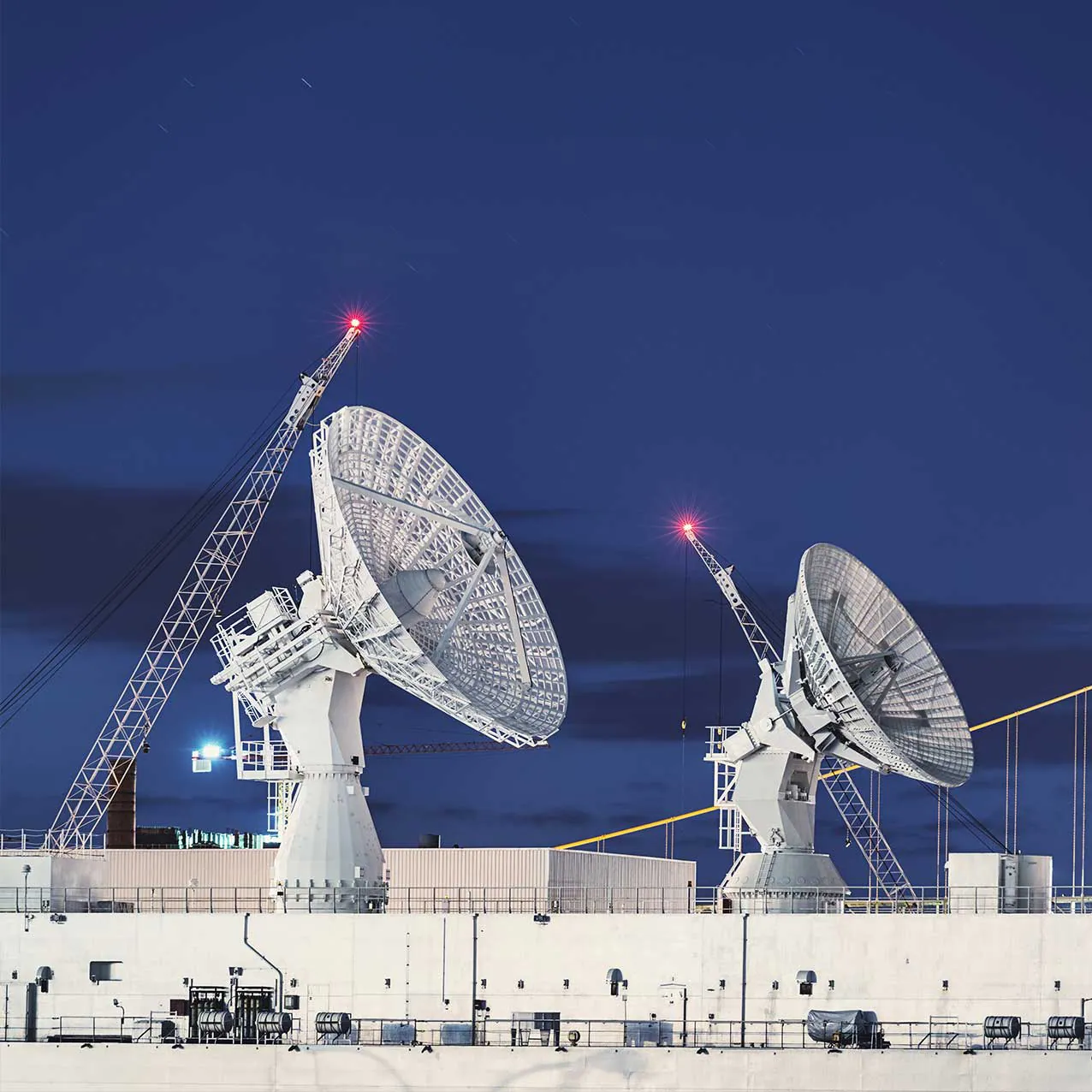 Two satellite antennas at night