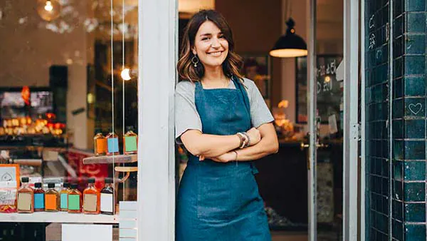 Small business owner confidently standing in shop doorway