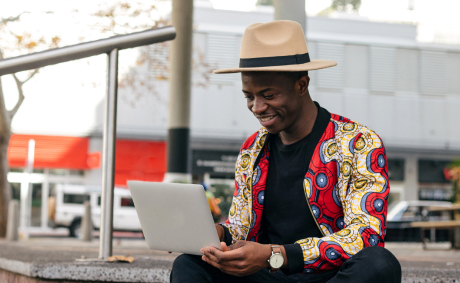 A man works on his laptop outside of a business center