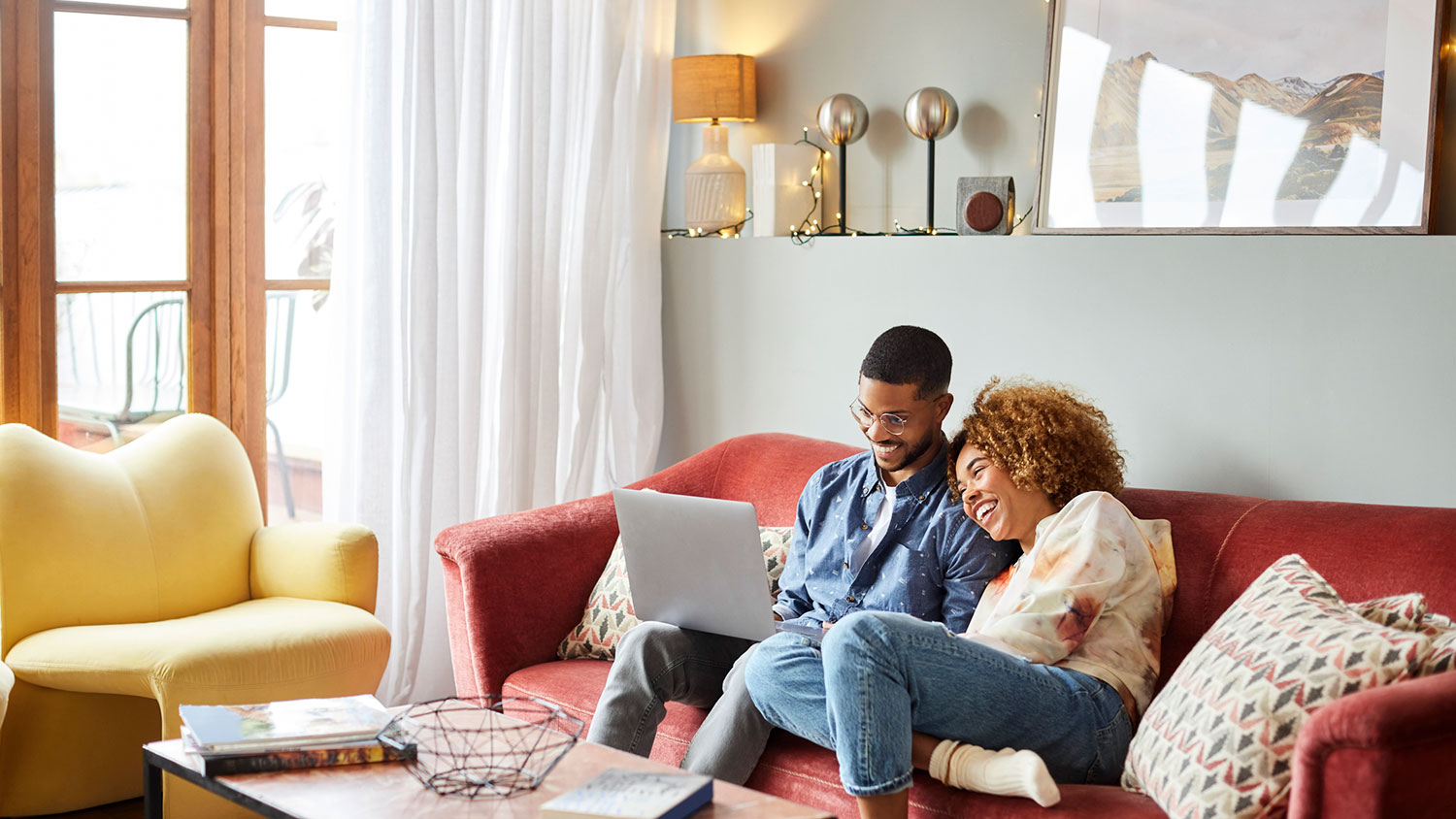 Couple snuggling on couch and using laptop