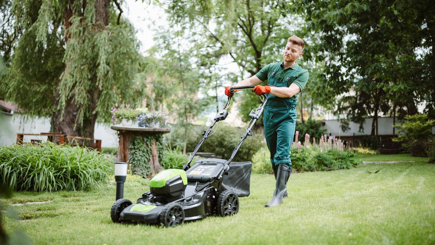 A professional gardener mowing lawn