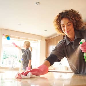 Two professionals cleaning a house’s kitchen