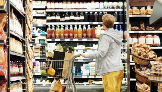 Consumer shopping in a grocery store with shopping cart