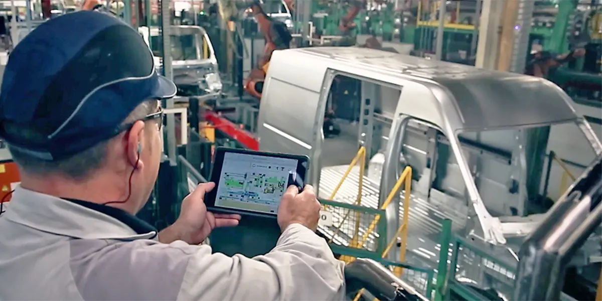 Worker using tablet to view data in car manufacturing plant