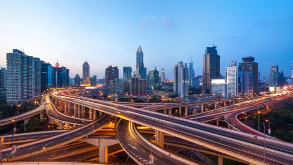 Intersecting highways with a city in the background