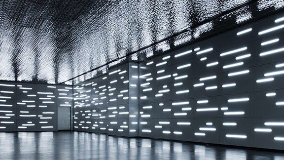 the corner of a room with walls covered in a video screen showing multiple lines