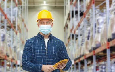 Warehouse worker in hard hat and protective mask