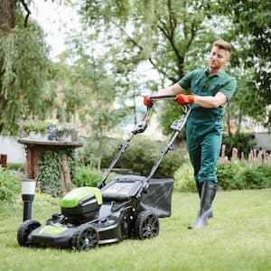 A professional gardener mowing lawn