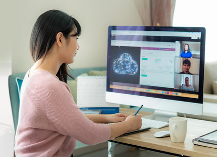 Mulher de cabelos escuros trabalhando em home office.