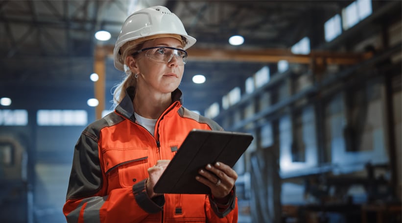 Female industrial worker holding an iPad in a factory setting