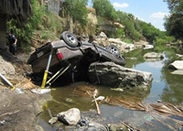 An example of the mayhem of human smuggling; this truck overturned when smugglers jumped out and left their human cargo to crash into the river.