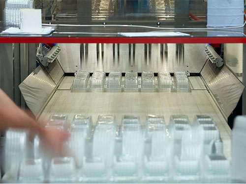 People working on a packaging factory machine