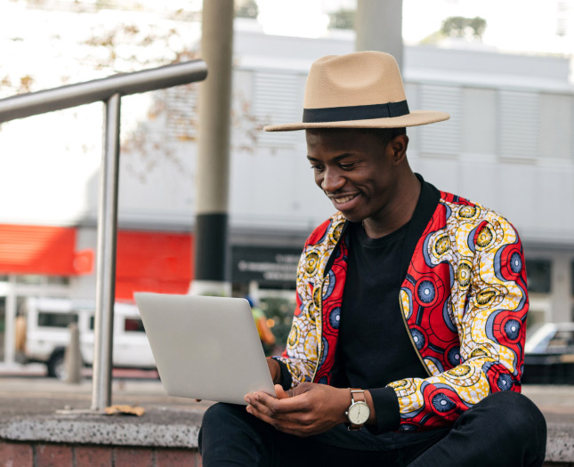 A man works on his laptop outside of a business center