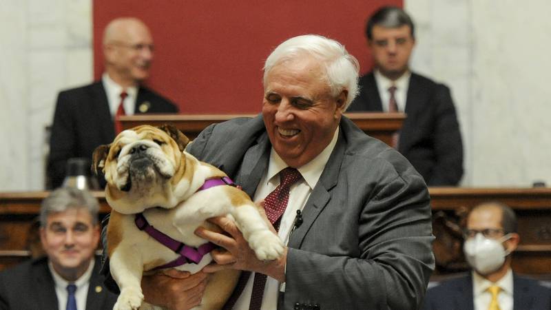 West Virginia Gov. Jim Justice holds up his dog Babydog as he comes to the end of his State of...