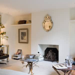 A living room with a desk and a fireplace in the basement