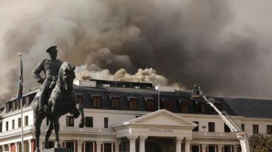 Firemen work at the parliament where a fire broke out in Cape Town, South Africa, January 3, 2022