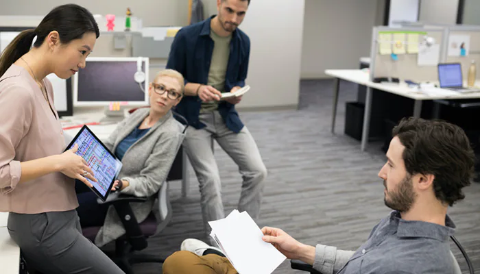 Four people talking in office setting