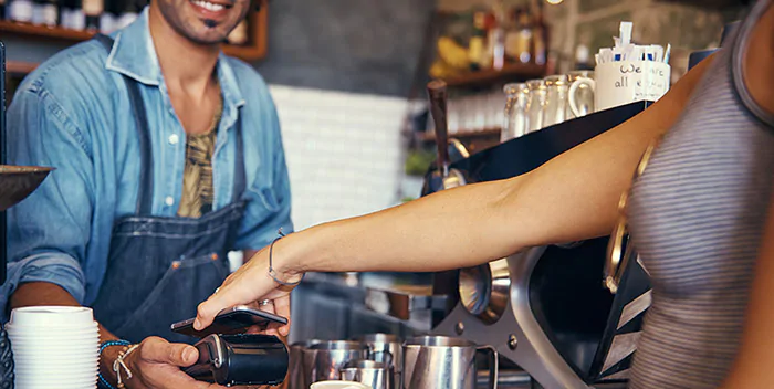 Person paying for coffee with mobile payment app