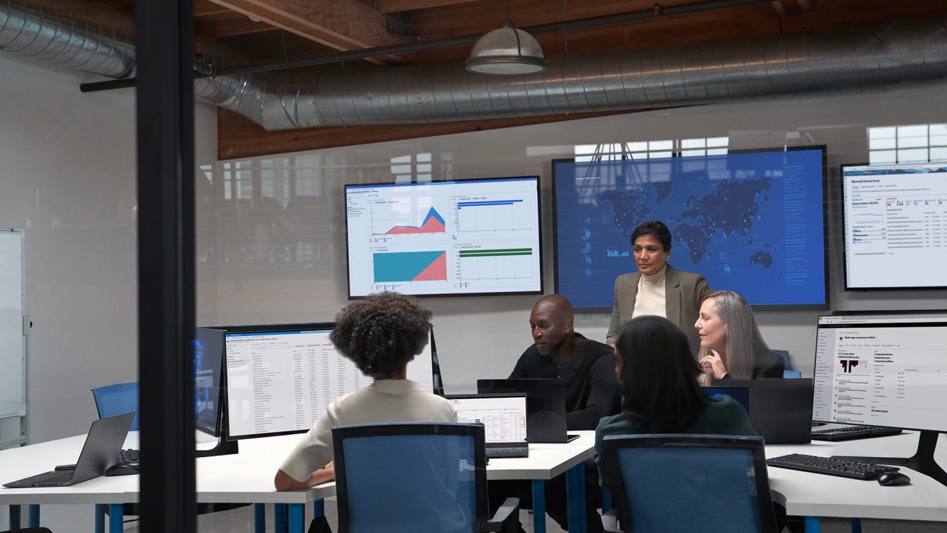 Five people reviewing data in a meeting room