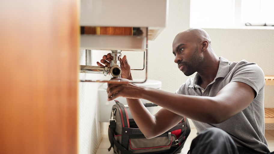 A plumber fixing a bathroom sink