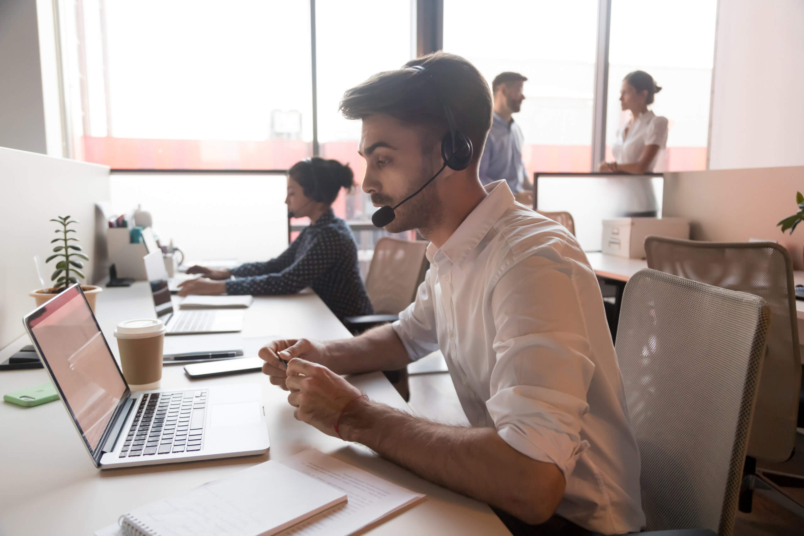 Call center agent wearing headset consulting client online. What are the types of contact center conceptl.