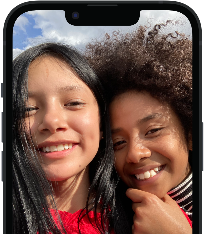 旁白功能正描述在 iPhone 上的圖像，並顯示語音朗讀的文字輸出「Two people smiling and posing for a photo.」