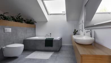 A modern bathroom with gray tiles and plants