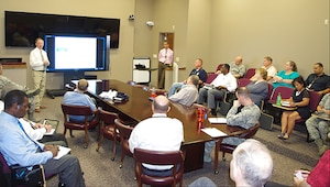 People seated in small auditorium with theater and conference room seating