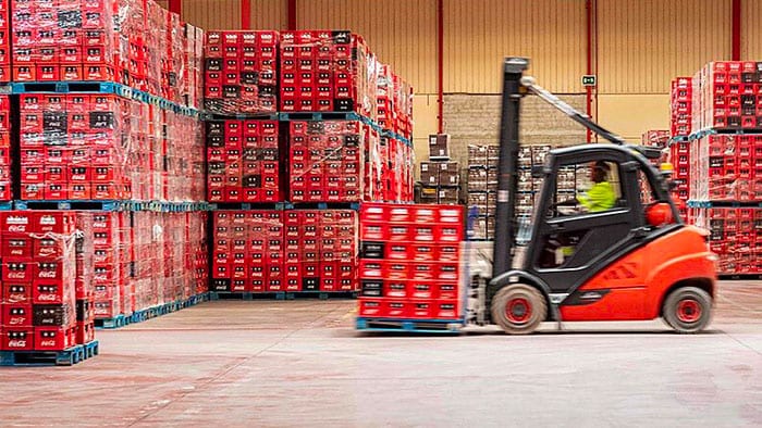 A fork lift moves bottles in a warehouse