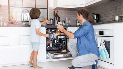 Father and son loading the dishwasher together