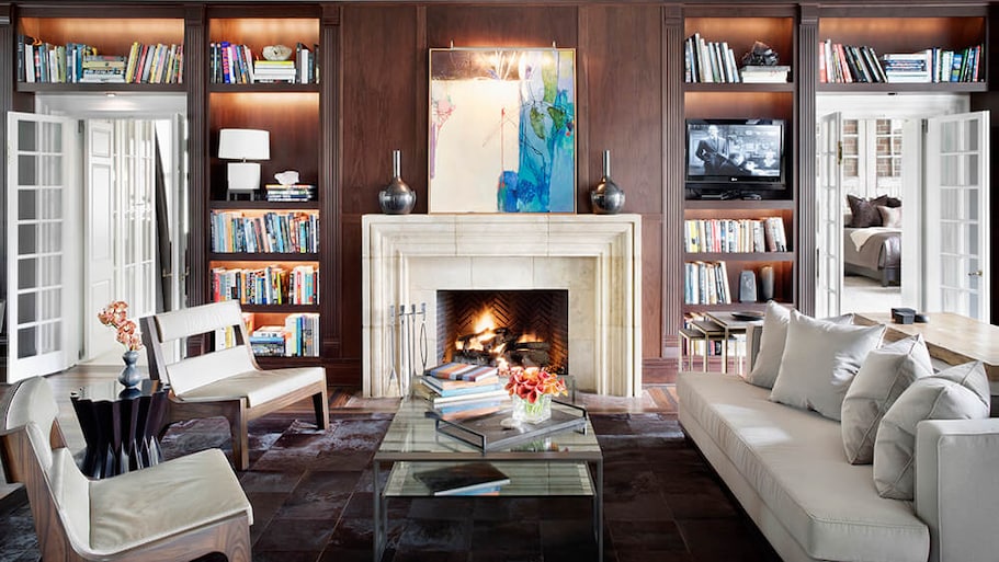 Library sitting room with built-in bookcases and a white fireplace