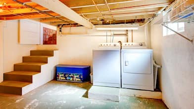 Basement laundry room with white appliances