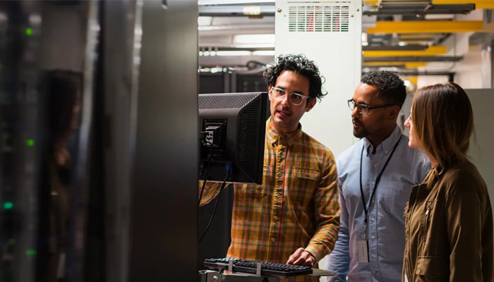 three people talking in a industrial plant