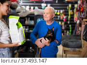 Pet store employee helps an elderly man choose dog food. Стоковое фото, фотограф Яков Филимонов / Фотобанк Лори