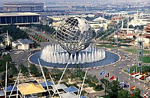 A spherical sculpture and several attractions line a park during a World's Fair.