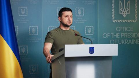 Volodomyr Zelensky standing at a podium