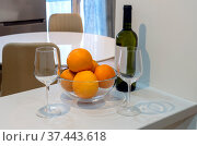 Two glasses, a bottle of white wine and a bowl of oranges close-up. Стоковое фото, фотограф Татьяна Ляпи / Фотобанк Лори