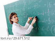 Female math teacher in front of the chalkboard. Стоковое фото, фотограф Elnur / Фотобанк Лори