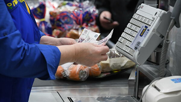 Кассир считает деньги в супермаркете сети Лента в Москве