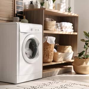 Modern washing machine and shelving unit in laundry room interior